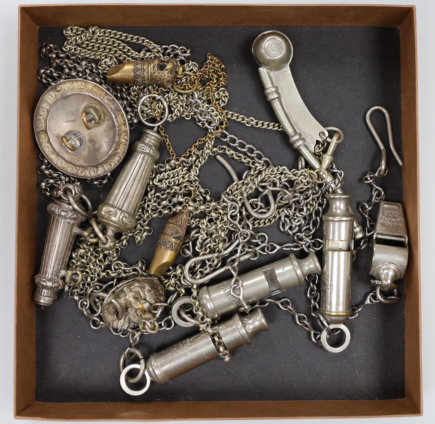 A large collection of 19th/20th century plated, nickel or horn whistles and two cut steel chatelaines, including two rifle brigade whistle, chain and lion mask, boson’s whistles ACME etc.